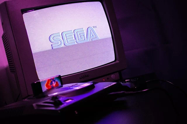 A CRT monitor playing a retro video game, with a classic console beside it