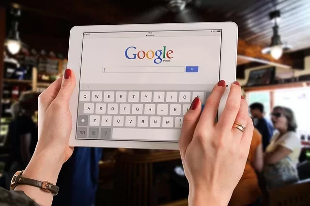 Google search bar and a person searching on a keyboard