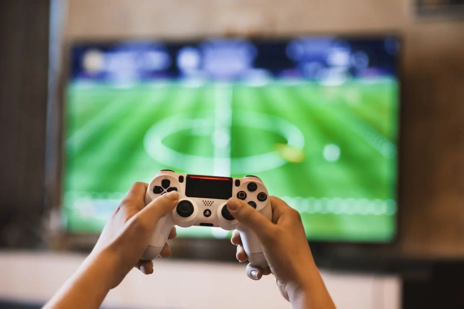 HDTV ekranında oyun kontrolcüsüyle birlikte maç yapan bir kullanıcı