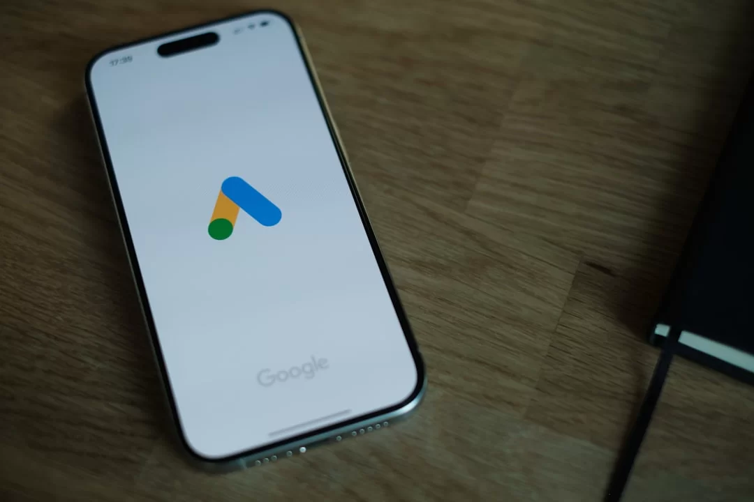 Masaüstünde duran bir cep telefonu ekranındaki Google Ads logosu
