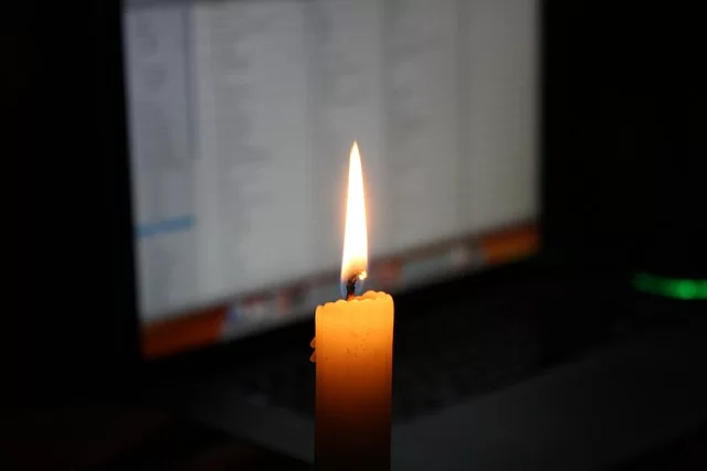 A candle lit in a working environment without electricity