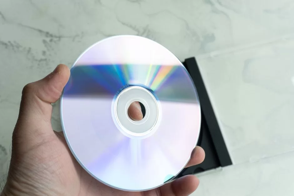 A person inspecting a DVD device with their hand