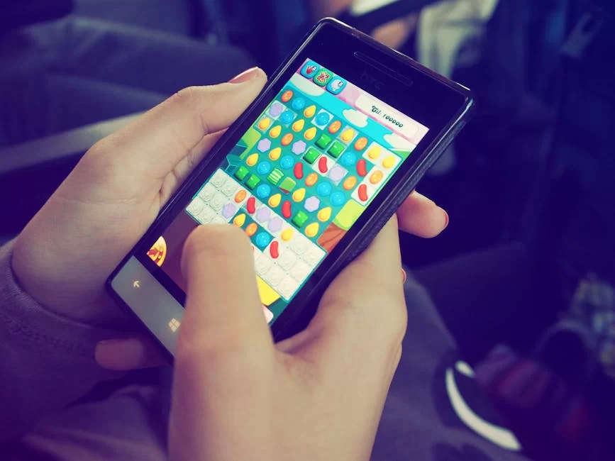 Akıllı telefon ekranında mobil oyun oynayan bir kişi