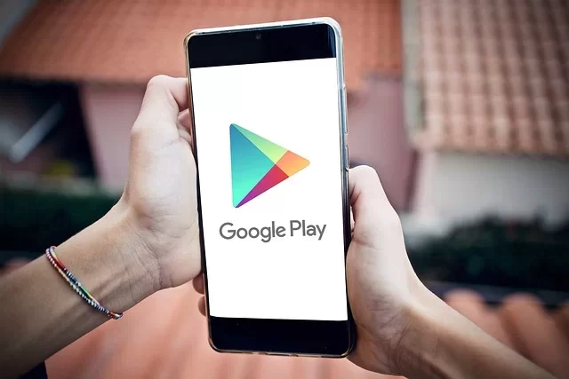 Akıllı telefon ekranında App Store ve Google Play Store logolarının yan yana gösterildiği görüntü
